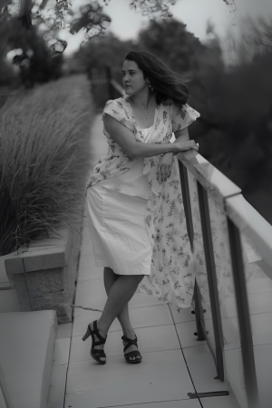 woman leaning against a balcony railing looking off into the distance
